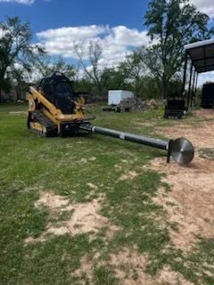Skid steer loader clearing overgrown lot with brush and tree removal