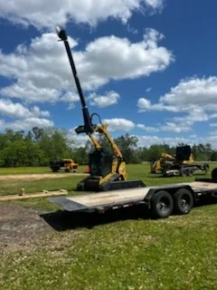 Flatbed trailer with telescopic boom lift transporting heavy excavation equipment